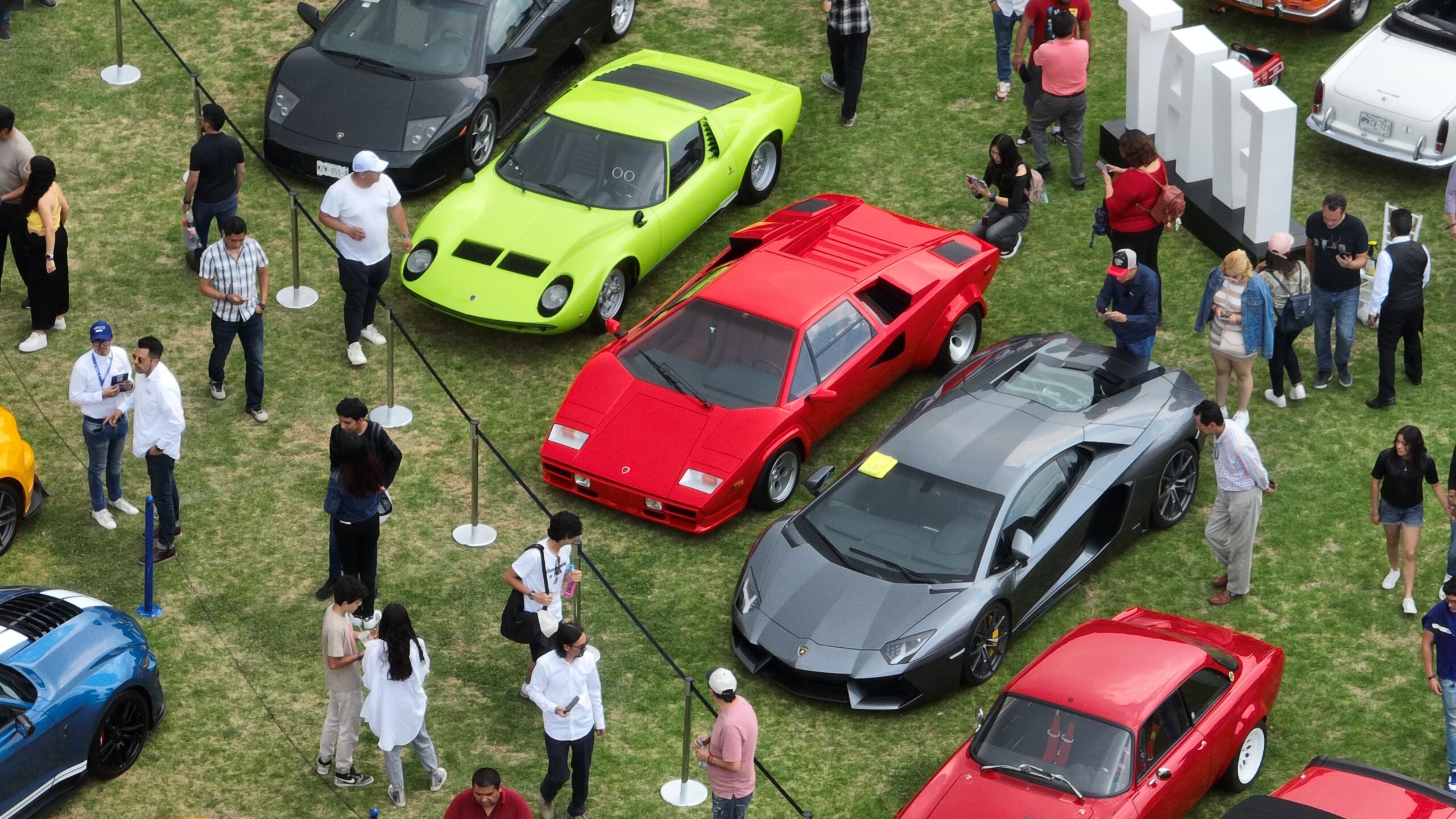 Automóvil clásico color rojo estacionado en un césped verde durante el Gran Concurso Internacional de Elegancia en Huixquilucan.